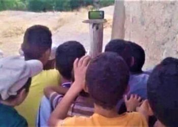 أطفال يتابعون المنتخب المغربي متحلقين حول هاتف