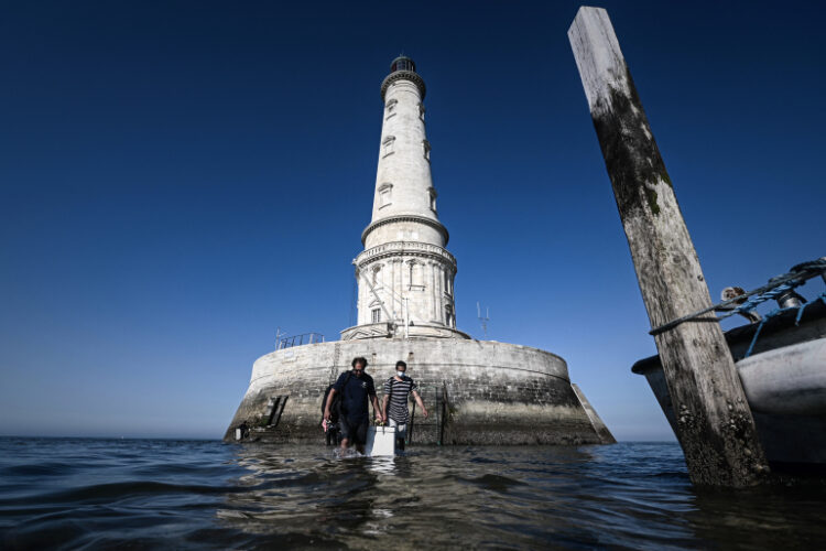Lighthouse keeper Thomas Dalisso (R), 38, is helped by his colleague Nicolas Quezel-Guerraz, 43, as he carries a wooden box containing his belongings before leaving   the Cordouan lighthouse off the coast of Le Verdon-sur-Mer, southwestern France on June 11, 2021. (Photo by Philippe LOPEZ / AFP)