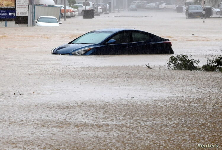 A car is partially submerged on a flooded street as Cyclone Shaheen makes landfall in Muscat Oman, October 3, 2021. REUTERS/Sultan Al Hassani NO RESALES. NO ARCHIVES