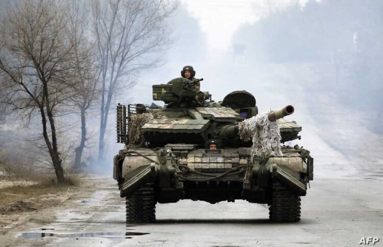 Ukrainian servicemen ride on tanks towards the front line with Russian forces in the Lugansk region of Ukraine on February 25, 2022. - Ukrainian forces fought off Russian troops in the capital Kyiv on the second day of a conflict that has claimed dozens of lives, as the EU approved sanctions targeting President Vladimir Putin.  Small arms fire and explosions were heard in the city's northern district of Obolonsky as what appeared to be an advance party of Russia's invasion force left a trail of destruction. (Photo by Anatolii STEPANOV / AFP)