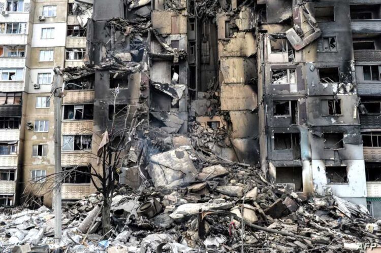 This picture shows an apartment building destroyed after shelling the day before in Ukraine's second-biggest city of Kharkiv on March 8, 2022. - The number of people fleeing the war flooding across Ukraine's borders to escape towns devastated by shelling and air strikes passed two million, in Europe's fastest-growing refugee crisis since World War II, according to the United Nations. (Photo by Sergey BOBOK / AFP)