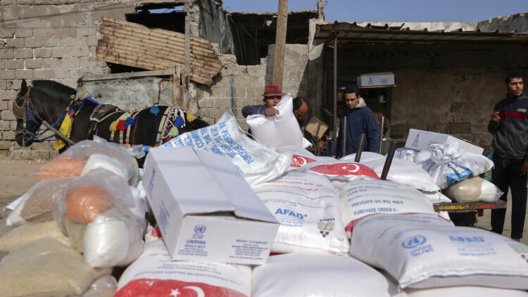 Palestinians collect food aid at a distribution center run by United Nations Relief and Works Agency (UNRWA), in Gaza City, on March 1, 2022.