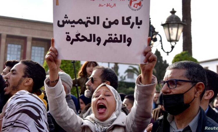 A Moroccan woman raises a placard as she takes part in a protest against rising prices, in front of the parliament in the capital Rabat, on February 20, 2022. (Photo by AFP)