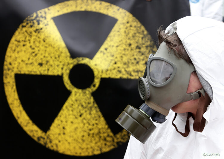 An activist wearing a mask and a protective suit protests against, what organisers said, the lack of safety of Belgian Nuclear power plants outside the Belgian Interior Ministry in Brussels, Belgium, February 1, 2016. REUTERS/Francois Lenoir