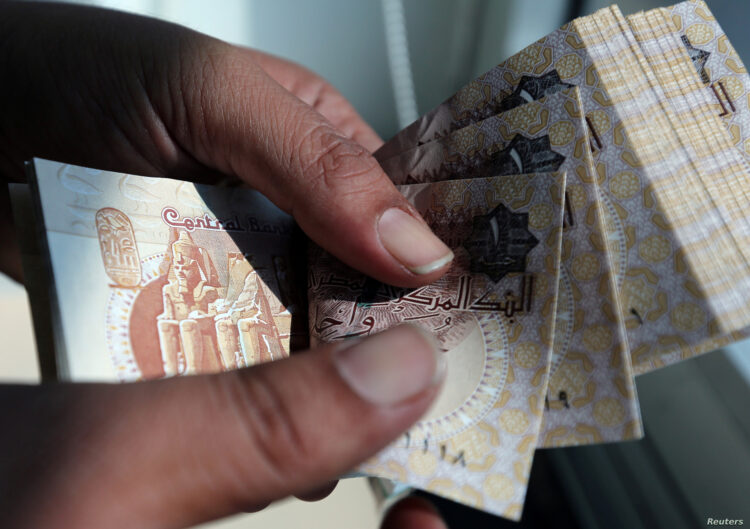 A man counts Egyptian pounds outside a bank in Cairo, Egypt October 24, 2016. Picture taken October 24, 2016. REUTERS/Mohamed Abd El Ghany