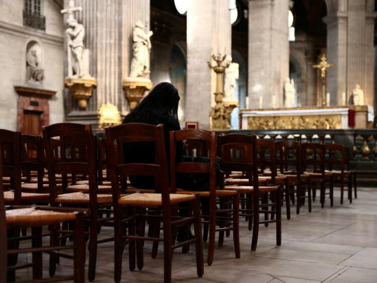 A woman prays inside the Saint-Sulpice church in Paris, France, October 4, 2021. Picture taken October 4, 2021. REUTERS/Sarah Meyssonnier