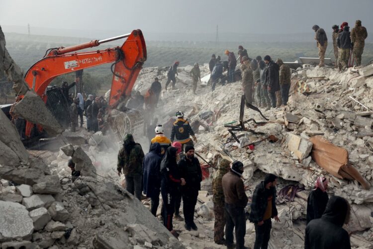 Residents and rescuers search for victims and survivors amidst the rubble of collapsed buildings following an earthquake in the village of Besnaya in Syria's rebel-held northwestern Idlib province on the border with Turkey, on February 6, 2022. - At least 1,293 people were killed and 3,411 injured across Syria today in an earthquake that had its epicentre in southwestern Turkey, the government and rescuers said. (Photo by OMAR HAJ KADOUR / AFP)
