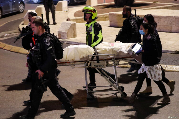 Police officers and medics evacuate a body, near Damascus Gate, in Jerusalem, December 4, 2021. REUTERS/Ammar Awad