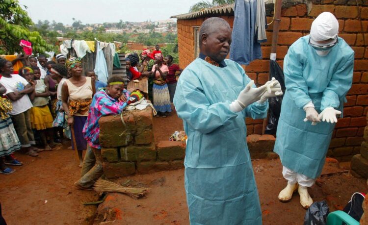 FILE PHOTO: FILE PHOTO: World Health Organisation (WHO) officials examine the home of a suspected Marburg virus victim in the northern Angolan town of Uige, April 19, 2005.   To match Special Report GLOBAL-PANDEMICS/BATS-SOLUTIONS  REUTERS/Mike Hutchings/File Photo/File Photo
