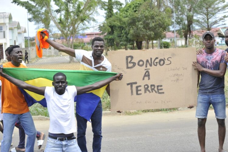 Residents hold a Gabon national flag as they celebrate in Libreville on August 30, 2023 after a group of Gabonese military officers appeared on television announcing they were "putting an end to the current regime" and scrapping official election results that had handed another term to veteran President Ali Bongo Ondimba. In a pre-dawn address, a group of officers declared "all the institutions of the republic" had been dissolved, the election results cancelled and the borders closed. (Photo by AFP)