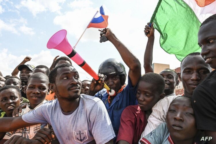 Supporters of the Niger's National Council for the Safeguard of the Homeland (CNSP) wave Russian and Niger flags at a demonstration ouside the Niger and French airbases in Niamey on August 27, 2023. (Photo by AFP)