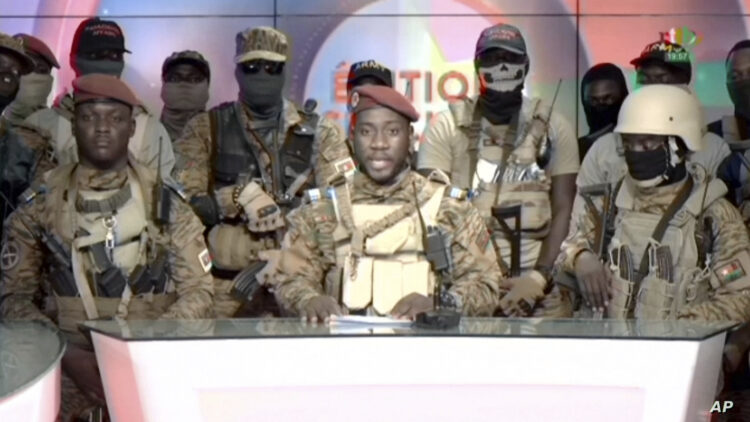 FILE - In this image from video broadcast by RTB state television, coup spokesman Capt. Kiswendsida Farouk Azaria Sorgho reads a statement in a studio in Ougadougou, Burkina Faso, on Sept. 30, 2022. There have been about 100 documented coups across Africa since the 1950s. This resurgence of military takeovers is often prompted by diminishing democratic dividends, according to analysts. (RTB via AP, File)