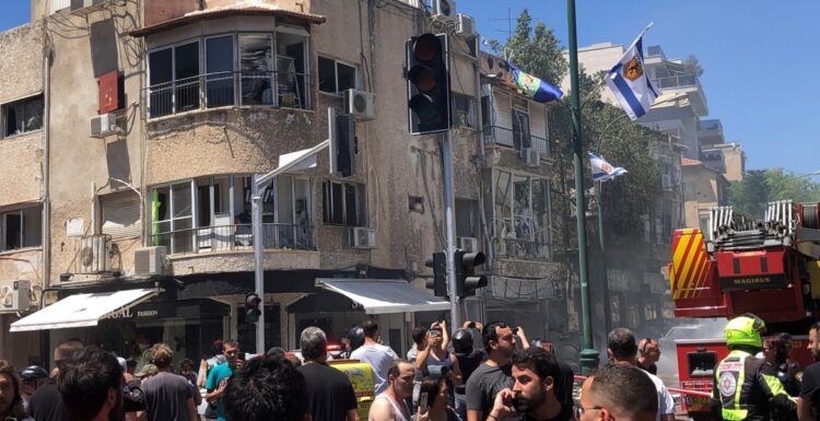 Pedestrians and first responders gather at the site hit by a rocket fired from Gaza, in Ramat Gan, Tel Aviv District, Israel May 15, 2021 in this image obtained from social media. Zvika Biran via REUTERS THIS IMAGE HAS BEEN SUPPLIED BY A THIRD PARTY. MANDATORY CREDIT. NO RESALES. NO ARCHIVES