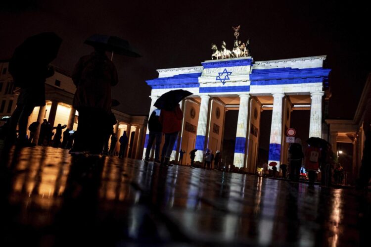 The Brandenburg Gate is illuminated in the colors of the Israeli flag as a show of solidarity, in Berlin, Germany, Saturday night, Oct. 7, 2023. (Fabian Sommer/dpa via AP)