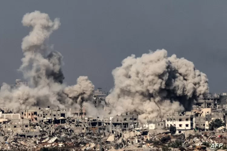 A picture taken from southern Israel near the border with the Gaza Strip on December 8, 2023, shows smoke rising above buildings during an Israeli strike in northern Gaza, amid continuing battles between Israel and the militant group Hamas. (Photo by JACK GUEZ / AFP)