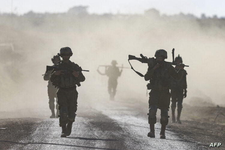 Israeli soldiers walk near the border with Gaza Strip in southern Israel on March 12, 2024, amid the ongoing battles between Israel and the Palestinian militant group Hamas. (Photo by Menahem KAHANA / AFP)