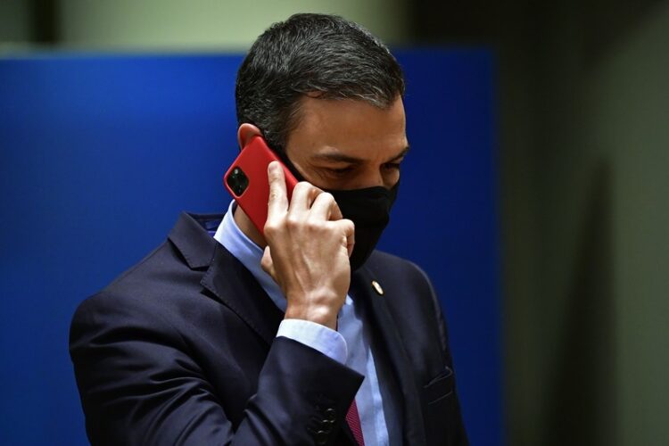 Spain's Prime Minister Pedro Sanchez, wearing a protective face mask, phones during an EU summit in Brussels on July 20, 2020, as the leaders of the European Union hold their first face-to-face summit over a post-virus economic rescue plan. (Photo by JOHN THYS / POOL / AFP)
