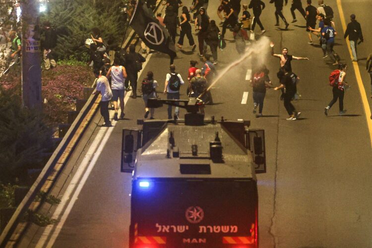 CORRECTION / Israeli police disperse demonstrators with a water canon during a protest against their current government and to demand a secure release of hostages held by the Palestinian Hamas movement in the Gaza Strip since the October 7 attacks, in Jerusalem on March 31, 2024. (Photo by AHMAD GHARABLI / AFP) / The erroneous mention[s] appearing in the metadata of this photo by AHMAD GHARABLI has been modified in AFP systems in the following manner: [on March 31, 2024] instead of [on March 32, 2024]. Please immediately remove the erroneous mention[s] from all your online services and delete it (them) from your servers. If you have been authorized by AFP to distribute it (them) to third parties, please ensure that the same actions are carried out by them. Failure to promptly comply with these instructions will entail liability on your part for any continued or post notification usage. Therefore we thank you very much for all your attention and prompt action. We are sorry for the inconvenience this notification may cause and remain at your disposal for any further information you may require.