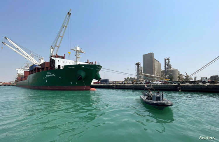 FILE PHOTO: A coastguard boat sails past a commercial container ship docked at the Houthi-held Red Sea port of Hodeidah, as a container ship carrying general commercial goods docked at the port for the first time since at least 2016, in Hodeidah, Yemen February 25, 2023. REUTERS/Khaled Abdullah/File Photo