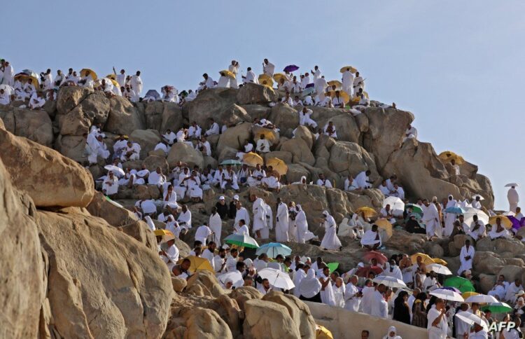 Muslim pilgrims gather atop Mount Arafat, also known as Jabal al-Rahma (Mount of Mercy), southeast of the Saudi holy city of Mecca, during the climax of the Hajj pilgrimage, on July 8, 2022. (Photo by Christina ASSI / AFP)