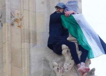 رجل يتسلق برج بيغ بن في لندن رافعا العلم الفلسطيني